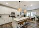 Modern kitchen with a large island, white cabinets, stainless steel appliances, and hardwood floors at 6950 Hidden Cove Ct, Castle Pines, CO 80108