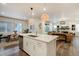 Open concept living space featuring a kitchen island, dining area, and comfortable seating at 6950 Hidden Cove Ct, Castle Pines, CO 80108