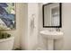 Elegant powder room with a pedestal sink, decorative art, and modern fixtures at 6950 Hidden Cove Ct, Castle Pines, CO 80108