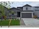 Charming two-story home with a covered porch, gray exterior, and well-manicured front yard at 1300 Loraine N Cir, Lafayette, CO 80026