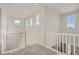 Hallway with natural light from multiple windows with carpet and white railing at 1300 Loraine N Cir, Lafayette, CO 80026