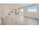 Open-concept living area with hard surface floors, white walls, big windows, and kitchen views at 1300 Loraine N Cir, Lafayette, CO 80026