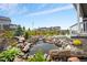 A charming pond and patio create a serene backyard retreat with wooden fence and lush landscaping at 1677 Meagan Way, Erie, CO 80516