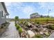Landscaped backyard with a stone paver walkway and a tranquil rock water feature at 1677 Meagan Way, Erie, CO 80516