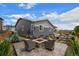 Backyard with comfortable patio seating, a fire pit, a water feature, and lovely landscaping at 1677 Meagan Way, Erie, CO 80516