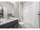 Well-lit bathroom with a vanity, a bathtub with a shower, and white tiled walls at 1677 Meagan Way, Erie, CO 80516