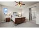 Bright bedroom featuring a ceiling fan, window, wood furniture and a door leading to the bathroom at 1677 Meagan Way, Erie, CO 80516