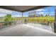 Covered patio with stone flooring overlooks manicured backyard, landscaping and wooden fence at 1677 Meagan Way, Erie, CO 80516