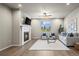 Warm living room features a cozy fireplace, comfortable seating, and views from the well-lit window at 1677 Meagan Way, Erie, CO 80516