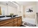 Bathroom featuring double sinks, wooden vanity and marble tile with tub at 1950 N Logan St # 108, Denver, CO 80203