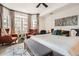Bright primary bedroom features large windows with curtains, sitting area and striped bedding at 1950 N Logan St # 108, Denver, CO 80203