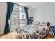 Bedroom with balcony access, hardwood floors, and stylish furnishings at 1950 N Logan St # 108, Denver, CO 80203