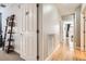 Hallway featuring wood floors, white walls and doors leading to other rooms at 1950 N Logan St # 108, Denver, CO 80203