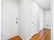 Hallway with hardwood floors, freshly painted white walls, and access to the bathroom at 525 Jackson St # 303, Denver, CO 80206