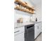 Modern kitchen features sleek countertops, stainless steel appliances and wooden floating shelves at 525 Jackson St # 303, Denver, CO 80206