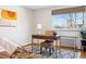 Bright home office with wooden desk, wicker chair, natural light, and stylish decor at 525 Jackson St # 303, Denver, CO 80206