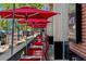 Sidewalk patio with red umbrellas and chairs, offering outdoor dining at 525 Jackson St # 303, Denver, CO 80206