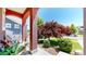 Charming front porch with red columns, a wooden bench, and a view of the landscaped front yard at 172 Painted Horse Way, Erie, CO 80516