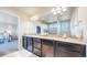 Double vanity bathroom with granite counters, dark wood cabinets, and mosaic tile backsplash creates a spa-like experience at 172 Painted Horse Way, Erie, CO 80516