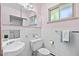 Bright bathroom featuring white tile, a vintage vanity, a toilet, and a window at 2501 E Arkansas Ave, Denver, CO 80210