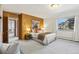 Bright bedroom featuring carpet, a queen-sized bed with throw pillows, and a view of the yard at 2501 E Arkansas Ave, Denver, CO 80210
