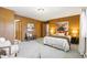 Spacious bedroom featuring hardwood wall paneling, carpeting, queen-sized bed and furniture at 2501 E Arkansas Ave, Denver, CO 80210
