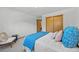 Cozy bedroom features a queen size bed, blue throw blanket, pillows, and a spacious closet at 2501 E Arkansas Ave, Denver, CO 80210