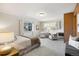 Carpeted bedroom featuring a queen-sized bed, two chairs, large window and accent wall at 2501 E Arkansas Ave, Denver, CO 80210