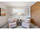 Cozy sitting area with patterned chairs, side table, decor, and bright natural light at 2501 E Arkansas Ave, Denver, CO 80210