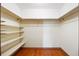Spacious walk-in closet with custom shelving and ample storage, and hardwood floors at 2501 E Arkansas Ave, Denver, CO 80210