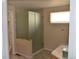 Bathroom featuring walk-in shower, light beige walls, and laminate flooring at 6123 S Quemoy Way, Aurora, CO 80015
