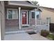 Inviting front porch with brick accents, offering a cozy spot to relax and enjoy the neighborhood view at 6123 S Quemoy Way, Aurora, CO 80015