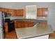 Well-lit kitchen features wood cabinetry, stainless steel appliances, and plenty of counter space for meal preparation at 6123 S Quemoy Way, Aurora, CO 80015