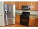 Close-up of stainless steel appliances, including a refrigerator and microwave, complementing the wood cabinets in this kitchen at 6123 S Quemoy Way, Aurora, CO 80015