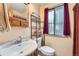 Classic bathroom with a pedestal sink, vintage faucet, shelving, and window, providing ample light at 2780 S Oakland W Cir, Aurora, CO 80014