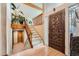Inviting foyer with a carved wood front door, bright white staircase, and a charming plant ledge at 2780 S Oakland W Cir, Aurora, CO 80014