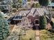 Aerial view of a brick home with a tiled roof, mature trees, a driveway, and a well-manicured front lawn at 50 S Eudora St, Denver, CO 80246