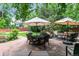 Stone patio featuring a dining table, lounge chairs, and shade umbrellas in a private backyard at 50 S Eudora St, Denver, CO 80246