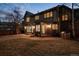 Exterior view of a home with a brick facade, a stone patio, a built-in grill and an expansive lawn, illuminated by outdoor lighting at 50 S Eudora St, Denver, CO 80246