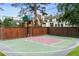 Outdoor basketball court with a cushioned surface, enclosed by a wooden and brick fence, providing a private recreational space at 50 S Eudora St, Denver, CO 80246