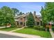 Charming brick home featuring lush landscaping, mature trees, and a well-manicured lawn at 50 S Eudora St, Denver, CO 80246