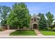 Beautiful brick home featuring an attached two-car garage, mature trees, and lovely landscaping at 50 S Eudora St, Denver, CO 80246