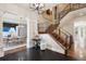 Grand foyer with a staircase, iron railings, dark herringbone floors, and views into the dining room at 50 S Eudora St, Denver, CO 80246