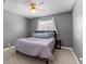 Bedroom features neutral walls, carpeting, ceiling fan, window, and neutral bedding at 12543 W Alameda Dr, Lakewood, CO 80228