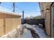 Cozy snow-covered patio with table, chairs, shed and a neutral brick wall at 12543 W Alameda Dr, Lakewood, CO 80228