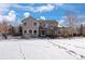Snow-covered backyard with a view of the house and a patio area at 1021 Neptunite Pl, Castle Rock, CO 80108