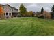 Large backyard with green lawn and home view at 1021 Neptunite Pl, Castle Rock, CO 80108