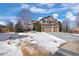 Two-story house with a snow-covered front yard and attached three-car garage at 1021 Neptunite Pl, Castle Rock, CO 80108