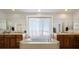 Main bathroom with double vanity, soaking tub, and large window at 1021 Neptunite Pl, Castle Rock, CO 80108