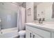 Full bathroom featuring gray tiles, a shower-tub combination, and a white vanity at 12345 Festival Ln, Thornton, CO 80241
